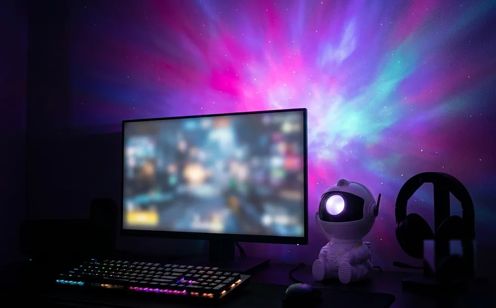 Escritorio gamer con la nebulosa del proyector cubriendo la pared del fondo